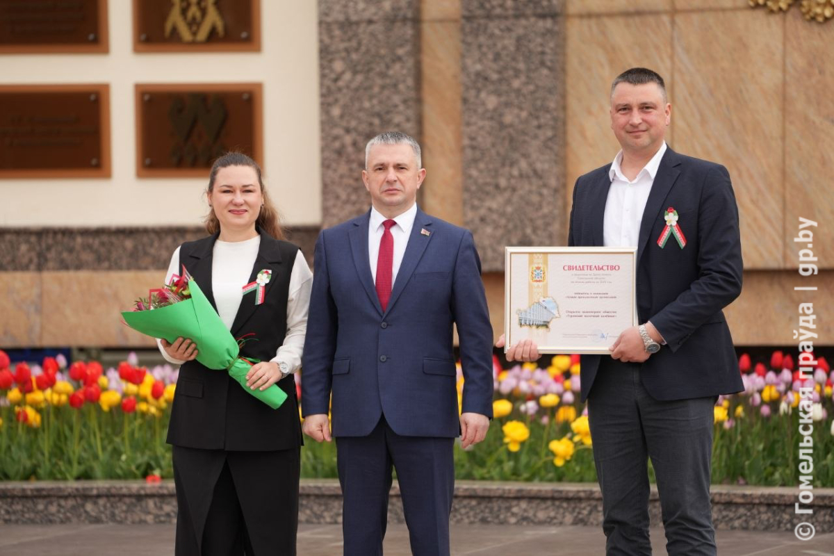Заместитель директора по производству Вадим Колядич и председатель профсоюзной первички, ведущий инженер-микробиолог Дарья Шкут получают свидетельство о занесении на областную Доску почета из рук губернатора Ивана Крупко